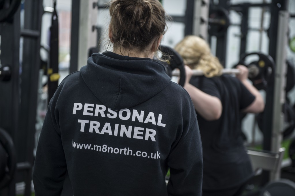 close up of the back of a personal trainer in branded hoody